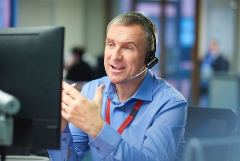 A Customer care / support worker talking to a customer through a headset