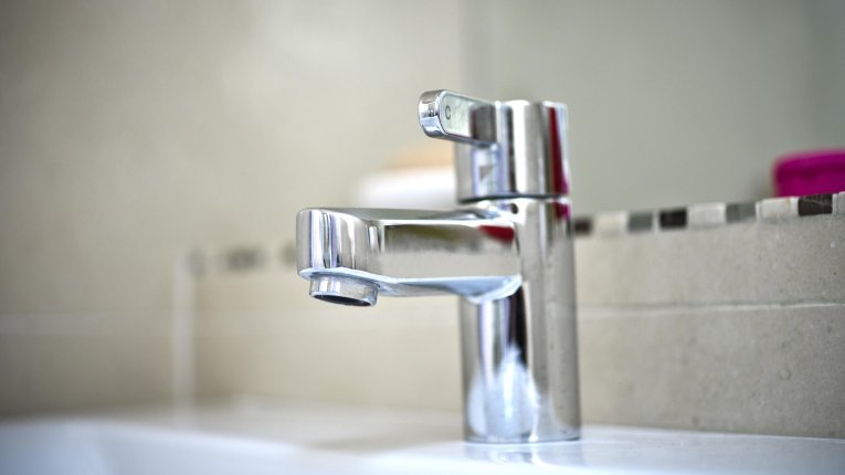 A silver tap within a home bathroom
