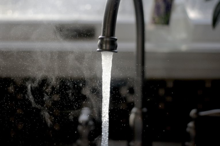Water running on a black tap