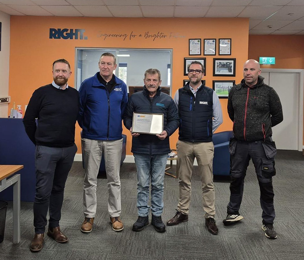 John Ahern awarded with an award with four other people inside an office