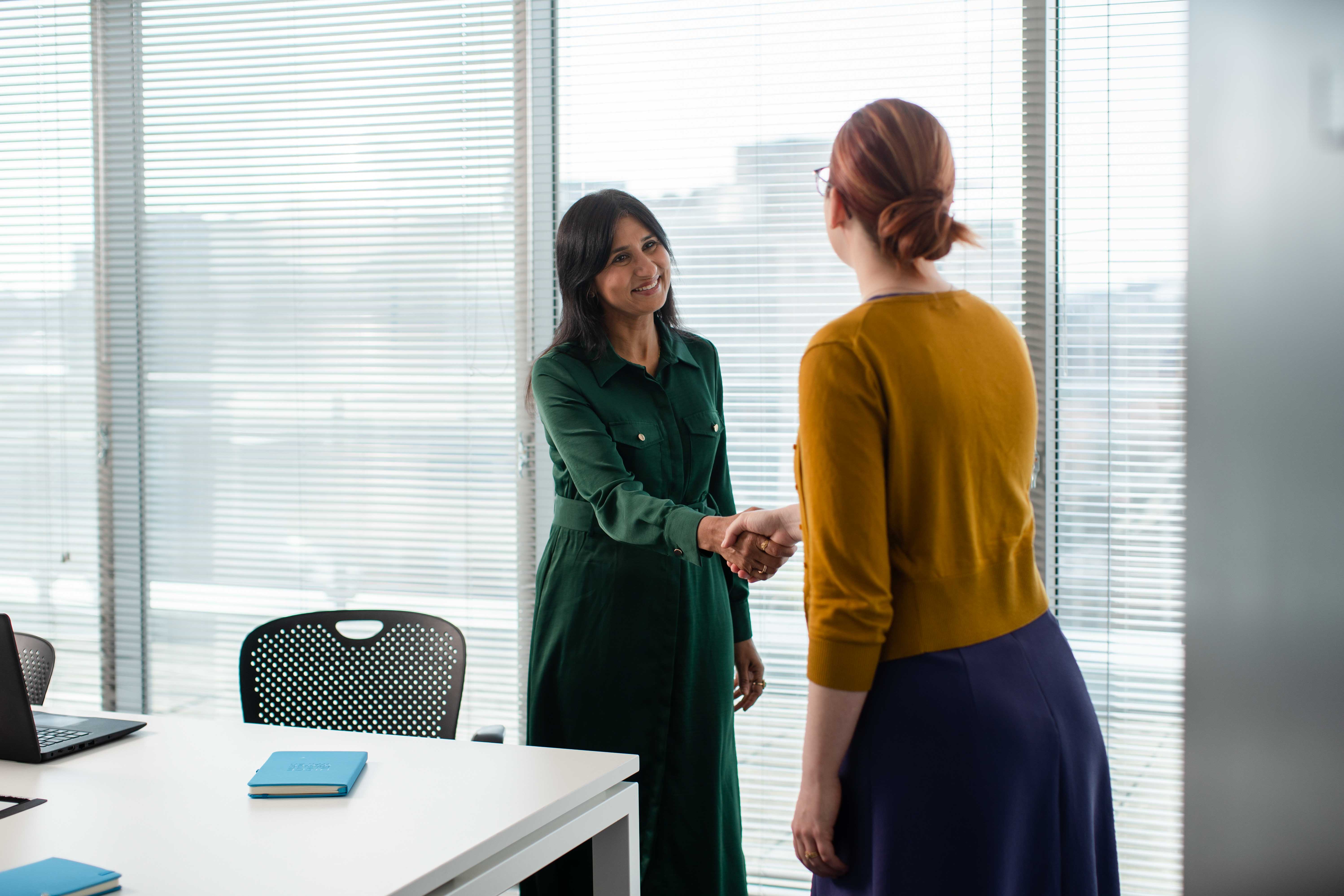 Two office workers shaking hands