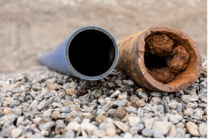 A corroded lead pipe and a plastic pipe