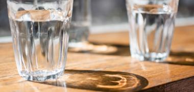 Close up of two glasses of water sitting on a table