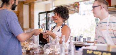 A woman in a cafe serving a customer
