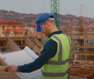 An engineer in a middle of a construction site looking at plans