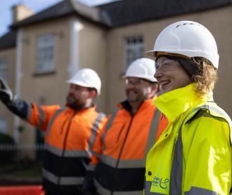 3 UÉ workers smiling at an LRP site