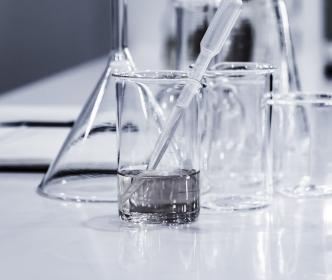 Science beaker with water and a dropper within
