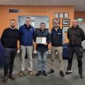 John Ahern awarded with an award with four other people inside an office