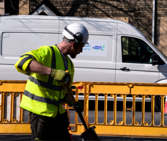 Uisce Éireann workers digging up the road with a shovel in hand