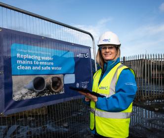 Lisa Cogan standing in front of a Uisce Éireann sign