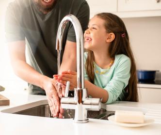 People washing hands under tap