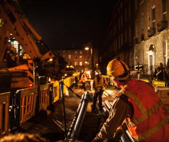 Workers laying pipe during nighttime
