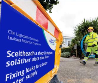 An Uisce Éireann worker holding some blue pipe on a site