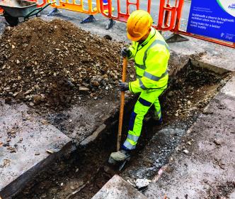 An Uisce Éireann worker digging on a site