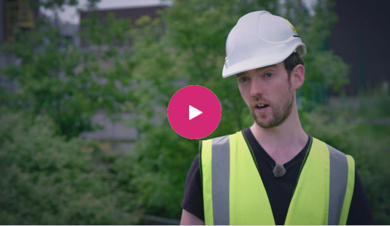 An engineer wearing a hardhat outside